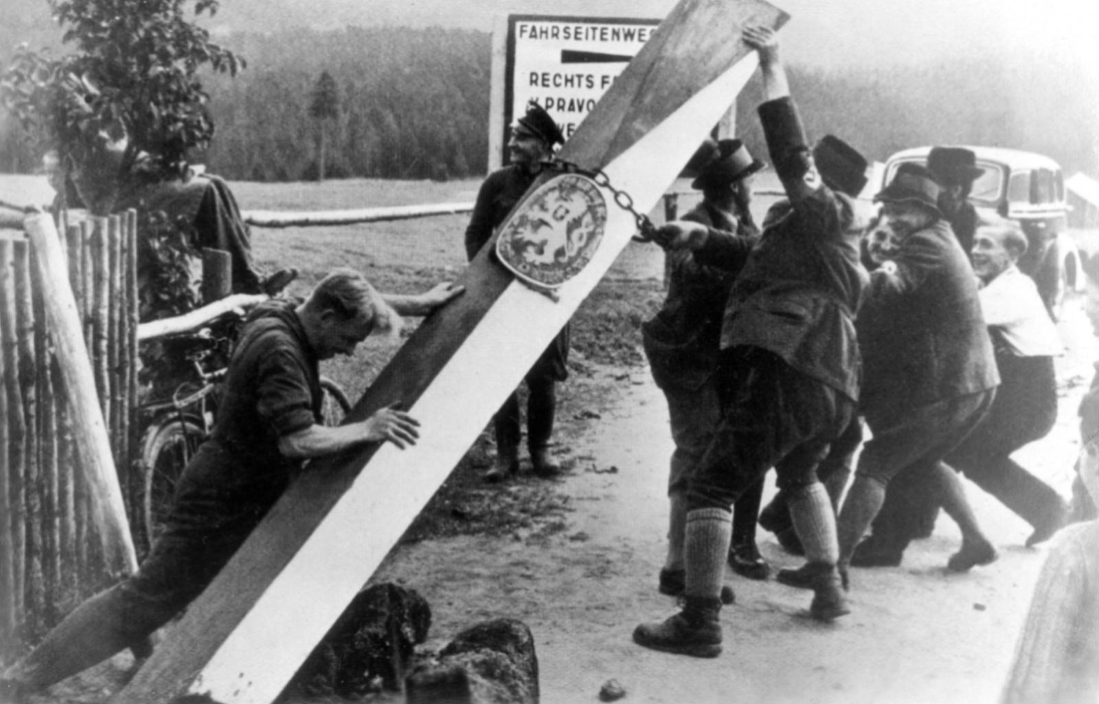 Сторонники Третьего рейха валят столб с символом Чехословакии.