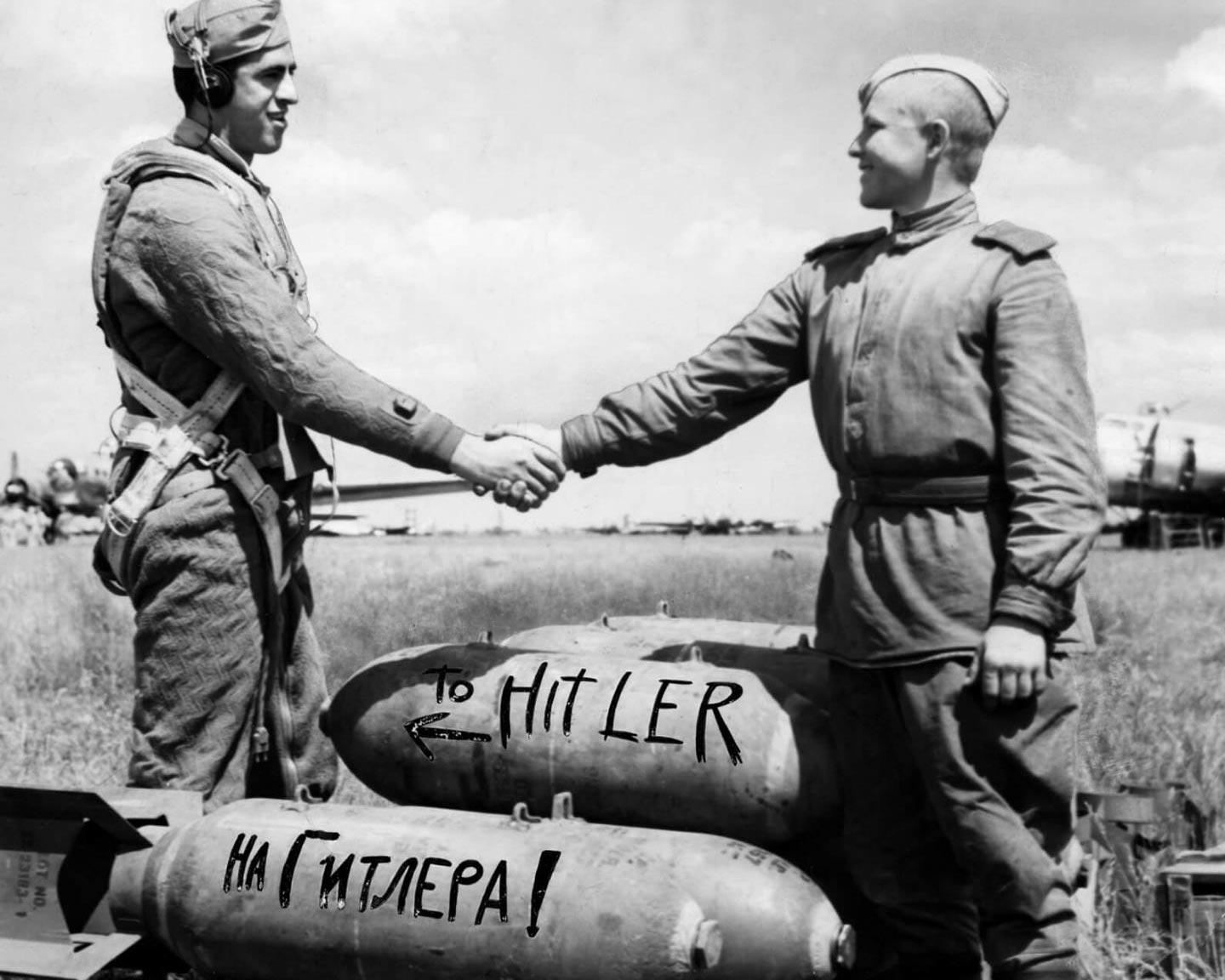 Американский лётчик и советский солдат пожимают руки над бомбами, 1944 год.