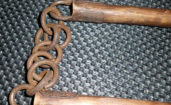 Деревянные нунчаку, соединенные цепью.