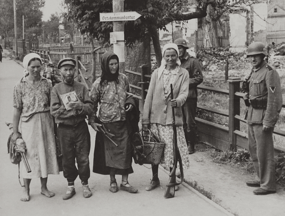Жители Минска несут ружья для сдачи в немецкую комендатуру, 1941.jpg