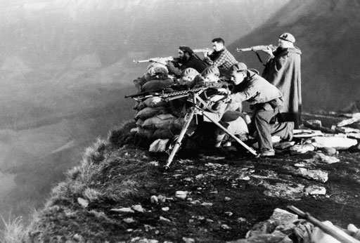 Фалангистские стрелки и пулеметчик на позиции вдоль скалистого фронта Уэска в северной Испании. 30 декабря 1936 года